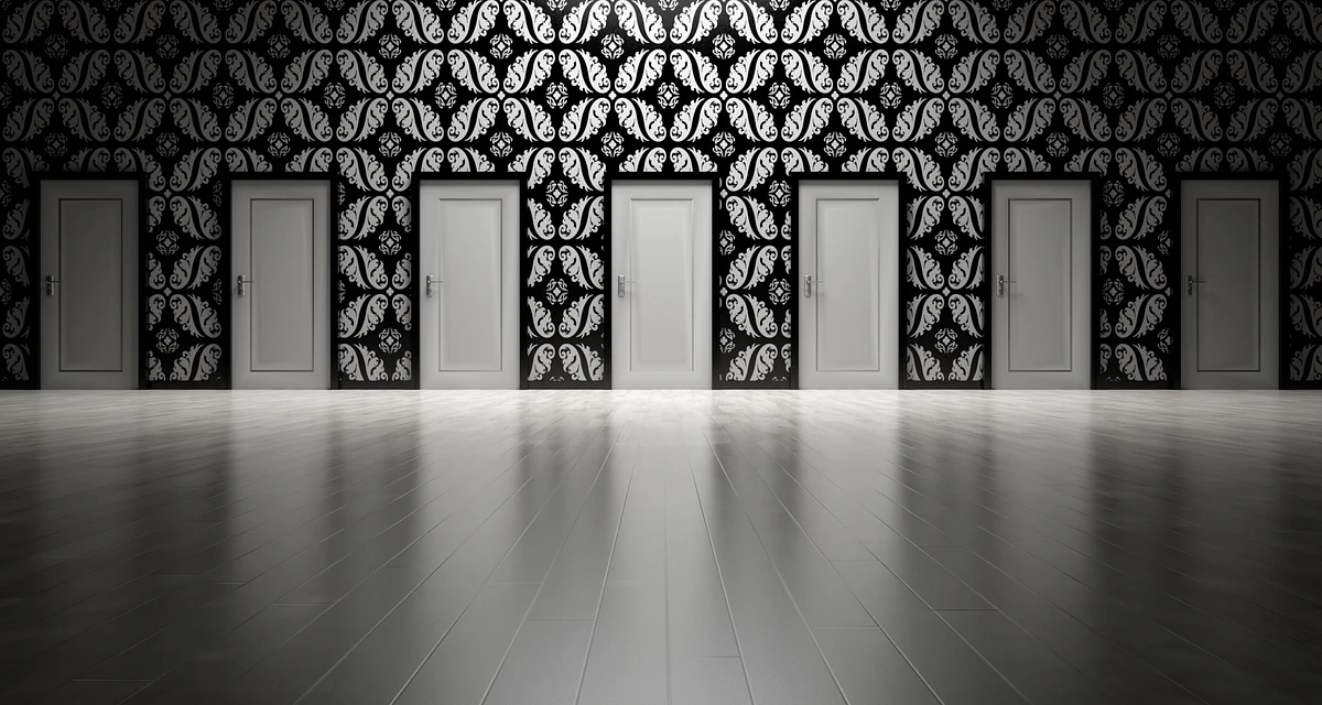 Several white doors, patterned wallpaper